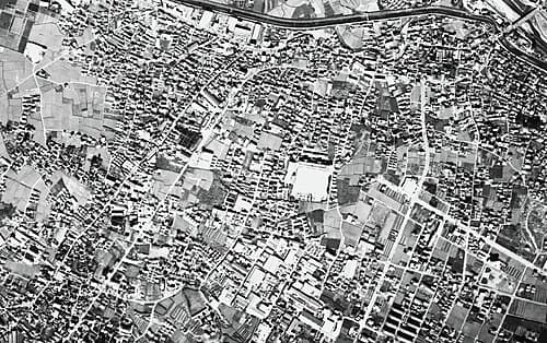 Dense settlement fabric beside a rail corridor